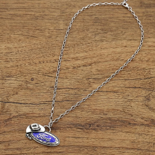 Silver necklace with a blue pendant on a wooden surface