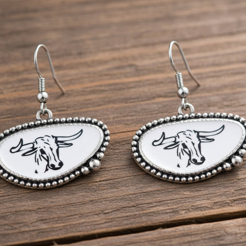 Pair of earrings with bull head design on a white background